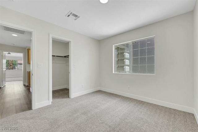 unfurnished bedroom with baseboards, visible vents, and carpet floors