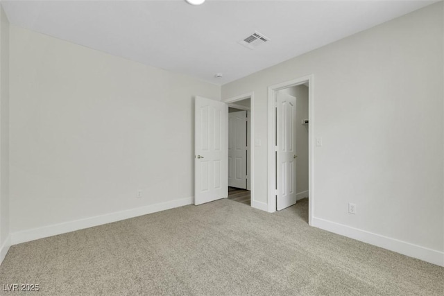 unfurnished bedroom featuring visible vents, baseboards, carpet floors, and a spacious closet