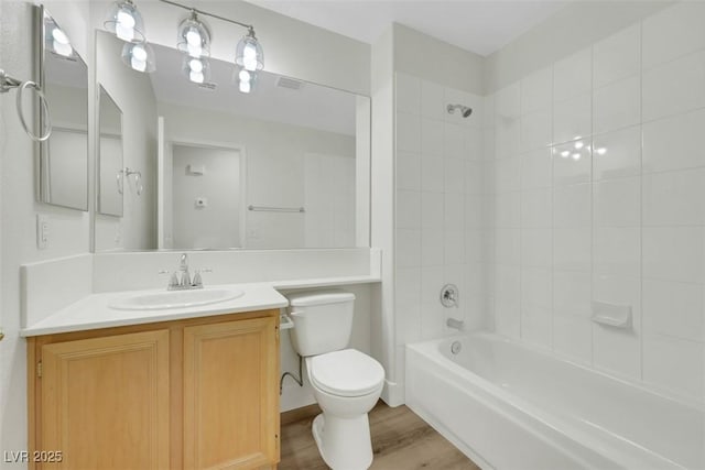 bathroom with wood finished floors, visible vents, toilet, vanity, and tub / shower combination