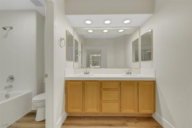 bathroom with wood finished floors, toilet, and a sink