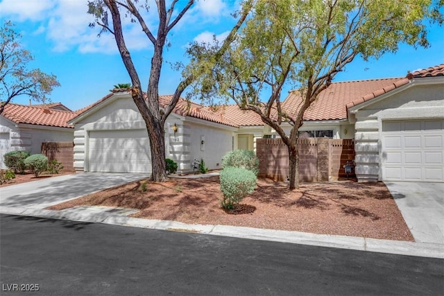 view of front of property with fence, a tiled roof, stucco siding, driveway, and a garage
