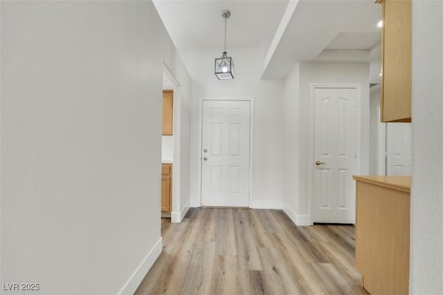 hallway with baseboards and light wood-style floors