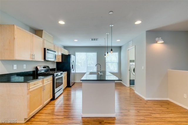 kitchen with stainless steel appliances, light brown cabinets, a sink, dark countertops, and recessed lighting