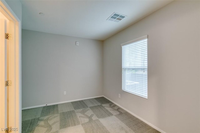 spare room with healthy amount of natural light, baseboards, and carpet floors