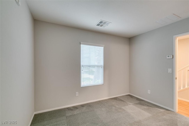 empty room featuring baseboards and carpet flooring