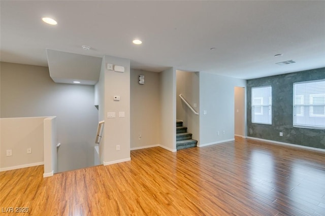 spare room featuring light wood-style flooring, baseboards, and recessed lighting