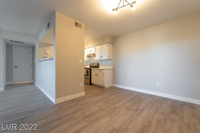 unfurnished living room with baseboards, visible vents, and light wood-style flooring