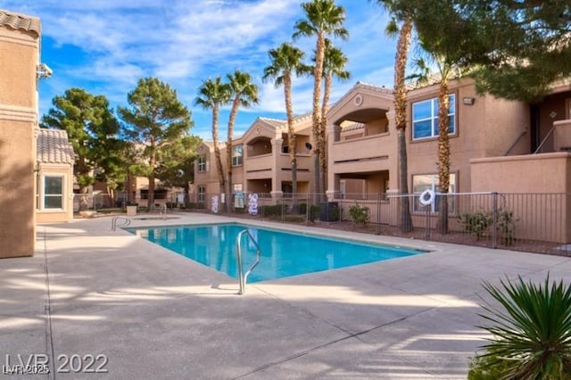 community pool featuring a patio area and fence