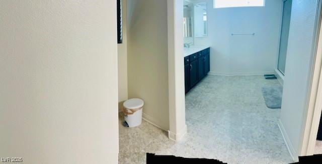 full bath with baseboards and vanity