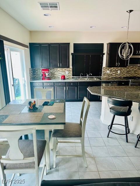 dining space with light tile patterned floors, an inviting chandelier, and visible vents
