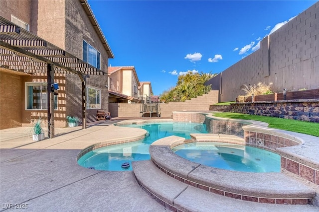 view of pool featuring a pool with connected hot tub, a patio area, and a fenced backyard