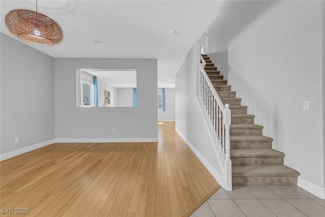 stairway featuring baseboards and wood finished floors
