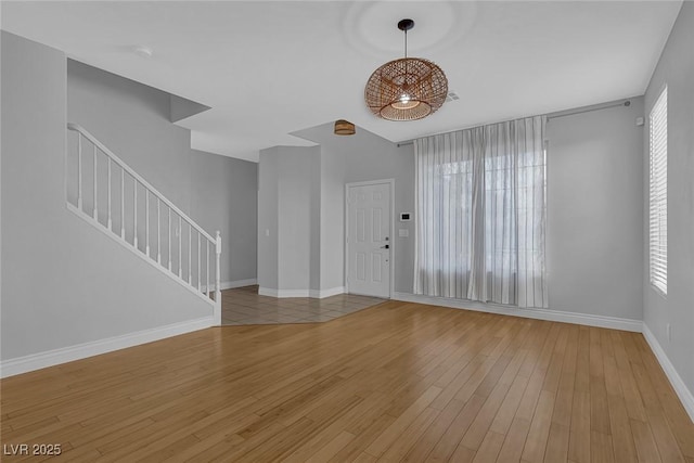 interior space with baseboards, wood finished floors, and stairs
