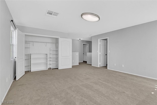 unfurnished bedroom featuring baseboards, visible vents, and light colored carpet
