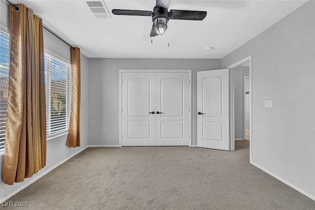 unfurnished bedroom with a closet, carpet, visible vents, and baseboards