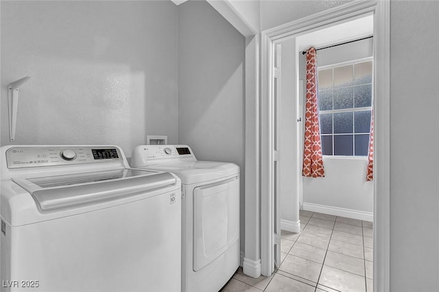 laundry room with baseboards, independent washer and dryer, laundry area, and light tile patterned flooring
