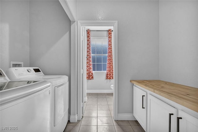 laundry room featuring light tile patterned floors, baseboards, cabinet space, and independent washer and dryer
