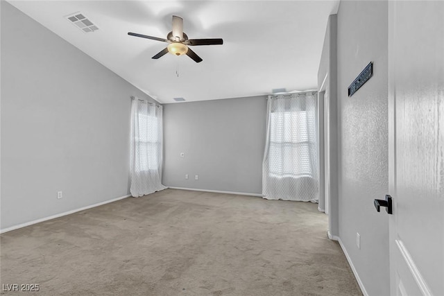 empty room with baseboards, a ceiling fan, visible vents, and carpet