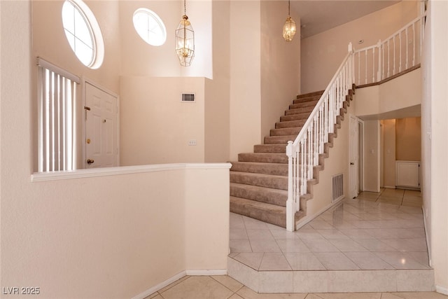 7620 Tortola Bay Ln, Las Vegas, NV 89128 - staircase featuring visible vents, a towering ceiling, and tile patterned flooring