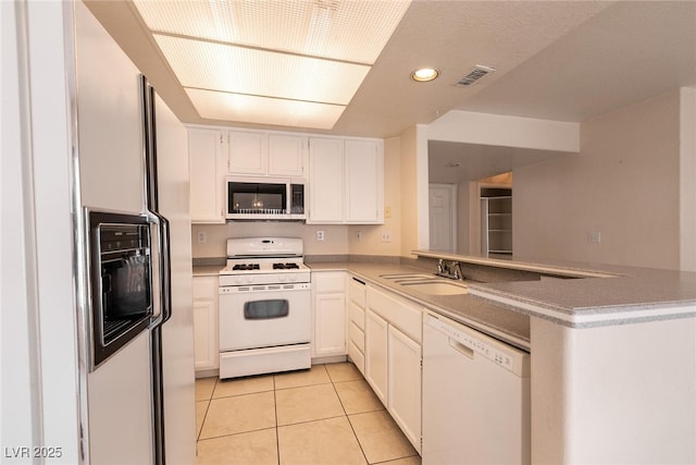 7620 Tortola Bay Ln, Las Vegas, NV 89128 - kitchen with a sink, light tile patterned floors, visible vents, a peninsula, and white appliances