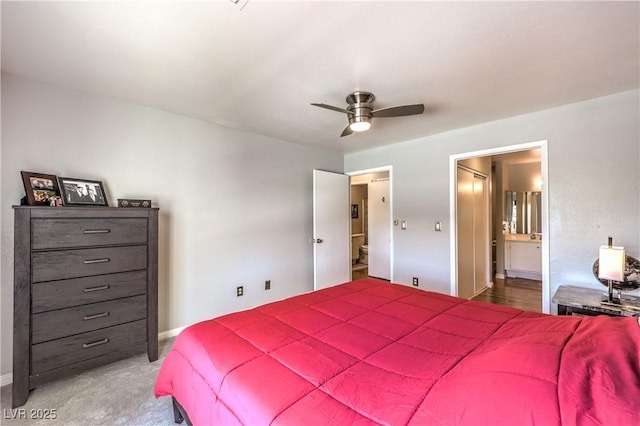 bedroom featuring a ceiling fan, ensuite bath, and baseboards