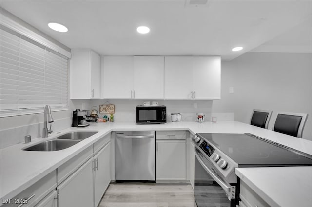 2080 Karen Ave Unit 1, Las Vegas, NV 89169 - kitchen with stainless steel appliances, a sink, light countertops, light wood finished floors, and recessed lighting