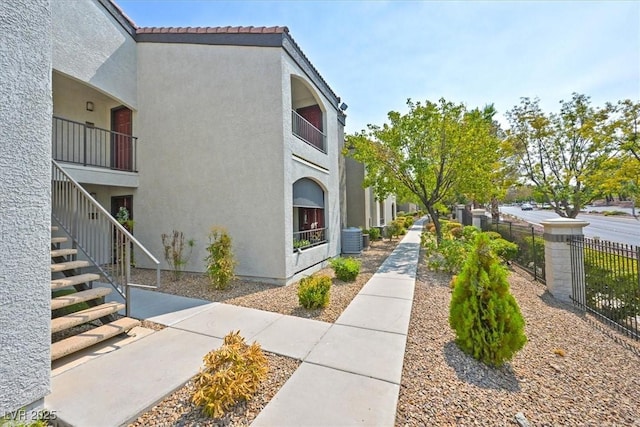 950 Seven Hills Dr Unit 116, Henderson, NV 89052 - view of side of home featuring stairs, fence, cooling unit, stucco siding, and a tile roof