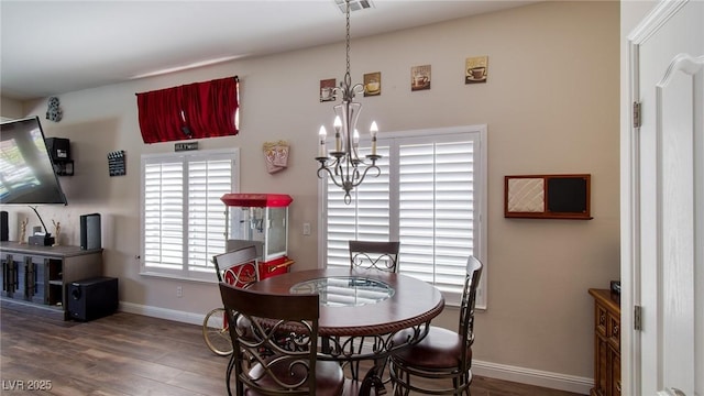 dining area featuring a chandelier, baseboards, wood finished floors, and visible vents