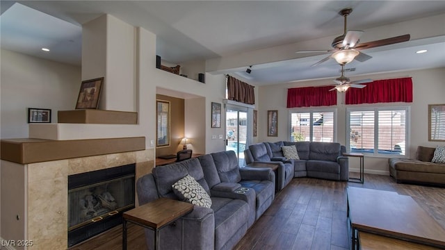 living area featuring a wealth of natural light, wood finished floors, and a ceiling fan