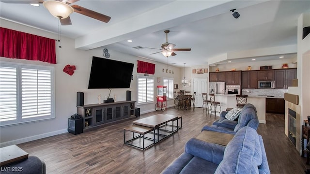 living area with beamed ceiling, ceiling fan, baseboards, recessed lighting, and wood finished floors