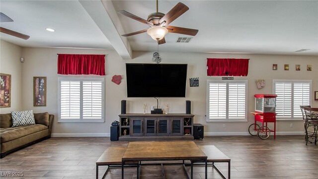 living room featuring wood finished floors, a healthy amount of sunlight, and a ceiling fan