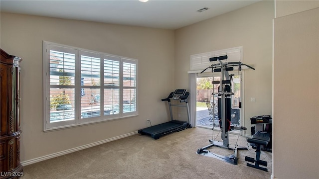 exercise area with visible vents, carpet, and baseboards