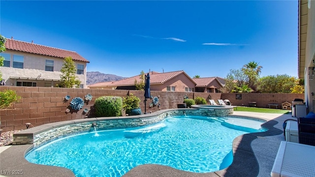 view of swimming pool featuring a fenced backyard and a pool with connected hot tub