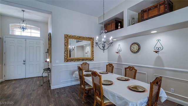 dining area featuring an inviting chandelier, wood finished floors, and wainscoting