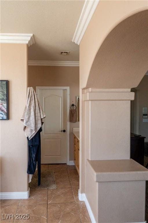 interior space featuring visible vents, baseboards, and crown molding