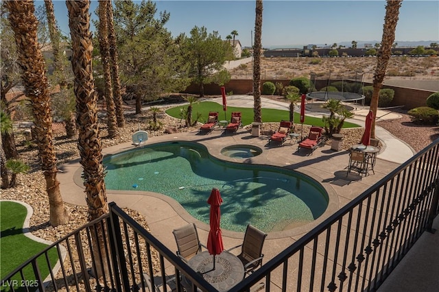 pool featuring a patio area, an in ground hot tub, and fence