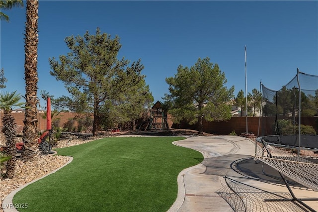 view of yard with a fenced backyard, a patio area, a playground, and a trampoline