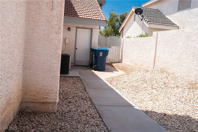 9704 Falling Star Ave, Las Vegas, NV 89117 - view of side of property featuring stucco siding, a tile roof, a gate, and central AC