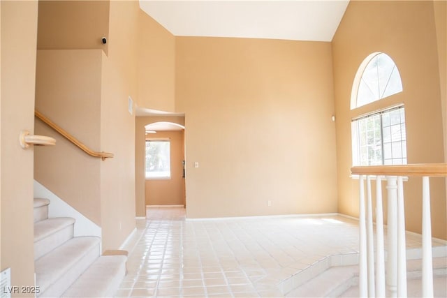 9704 Falling Star Ave, Las Vegas, NV 89117 - entryway with a towering ceiling, arched walkways, stairway, and baseboards
