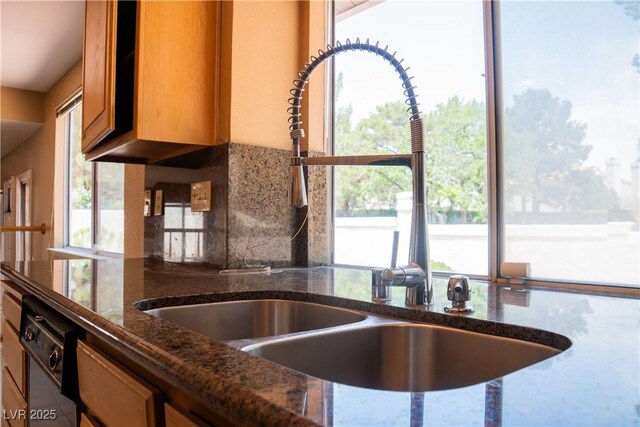 9704 Falling Star Ave, Las Vegas, NV 89117 - kitchen view of a sink, dark stone countertops, backsplash, and brown cabinets