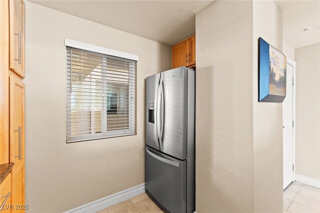 220 E Flamingo Rd Unit 111, Las Vegas, NV 89169 - kitchen featuring stainless steel fridge, light tile patterned flooring, and baseboards