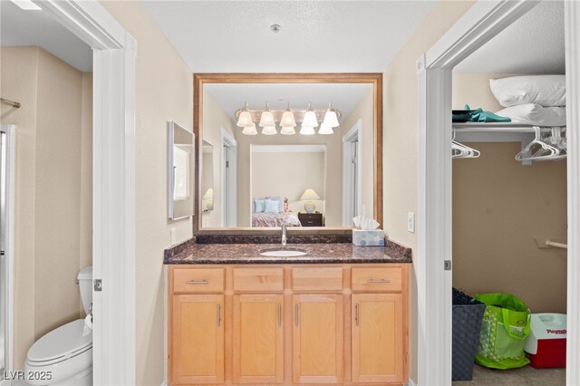 220 E Flamingo Rd Unit 111, Las Vegas, NV 89169 - bathroom featuring toilet, ensuite bathroom, vanity, and a spacious closet