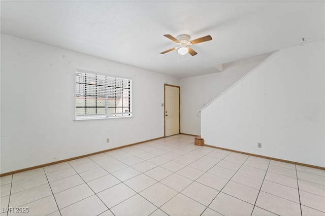 spare room with baseboards and ceiling fan