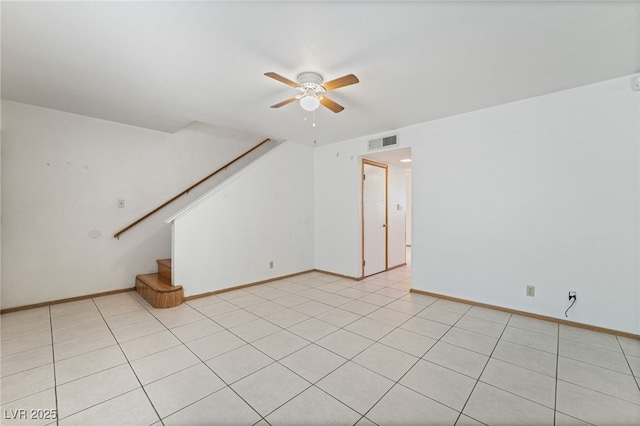 unfurnished living room featuring baseboards, a ceiling fan, visible vents, and stairs