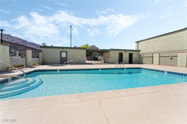 community pool featuring fence and a patio area