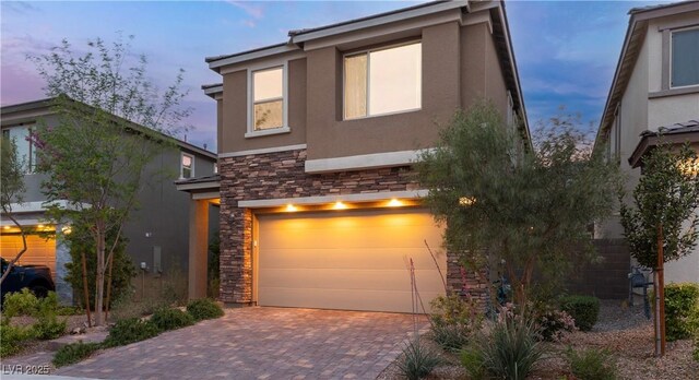 397 Purple Sandpiper St, Las Vegas, NV 89138 - view of front facade featuring stone siding, stucco siding, an attached garage, and decorative driveway