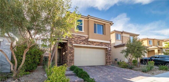 397 Purple Sandpiper St, Las Vegas, NV 89138 - townhome / multi-family property featuring stucco siding, stone siding, an attached garage, and driveway