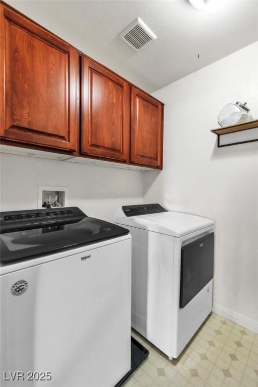 laundry area with washing machine and clothes dryer, cabinet space, light flooring, and baseboards