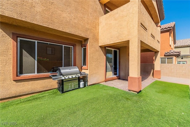 rear view of property with stucco siding and a patio