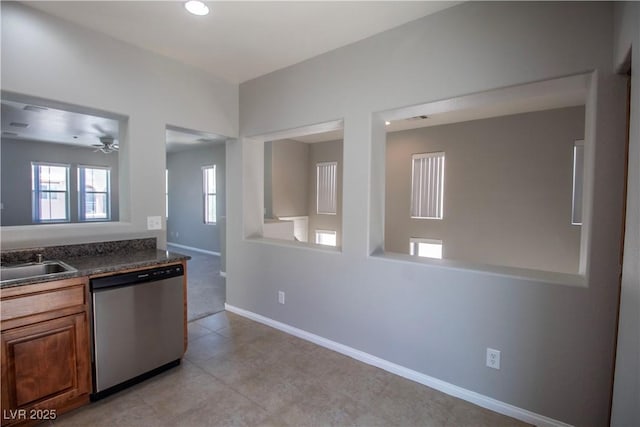 6652 Weeping Pine St, Las Vegas, NV 89149 - kitchen featuring stainless steel dishwasher, dark countertops, brown cabinets, a sink, and baseboards